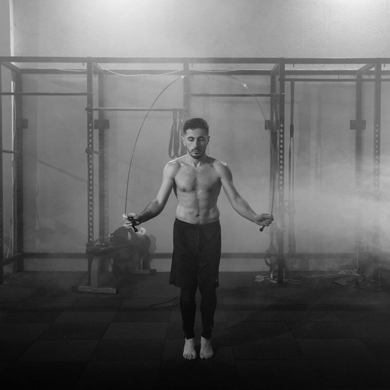 Man in mid-motion during a dynamic exercise in a modern gym.